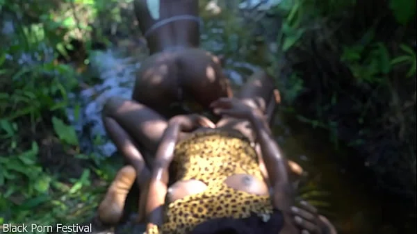 2 African tribe girls jerking off their chief with their asses in the river