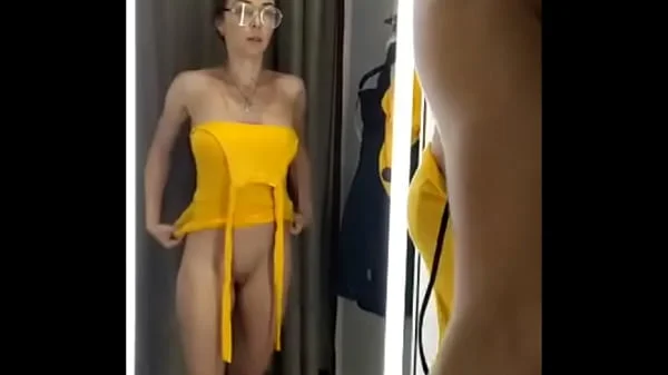Girl changes clothes in fitting room.