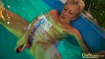 Gorgeous mature blonde Jitka is touching her shaved pussy in the pool